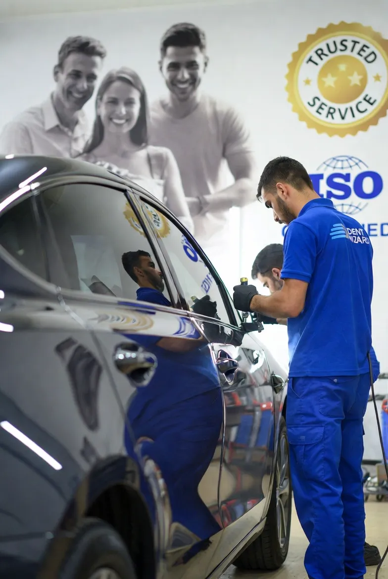worker fixing car dents in workshop